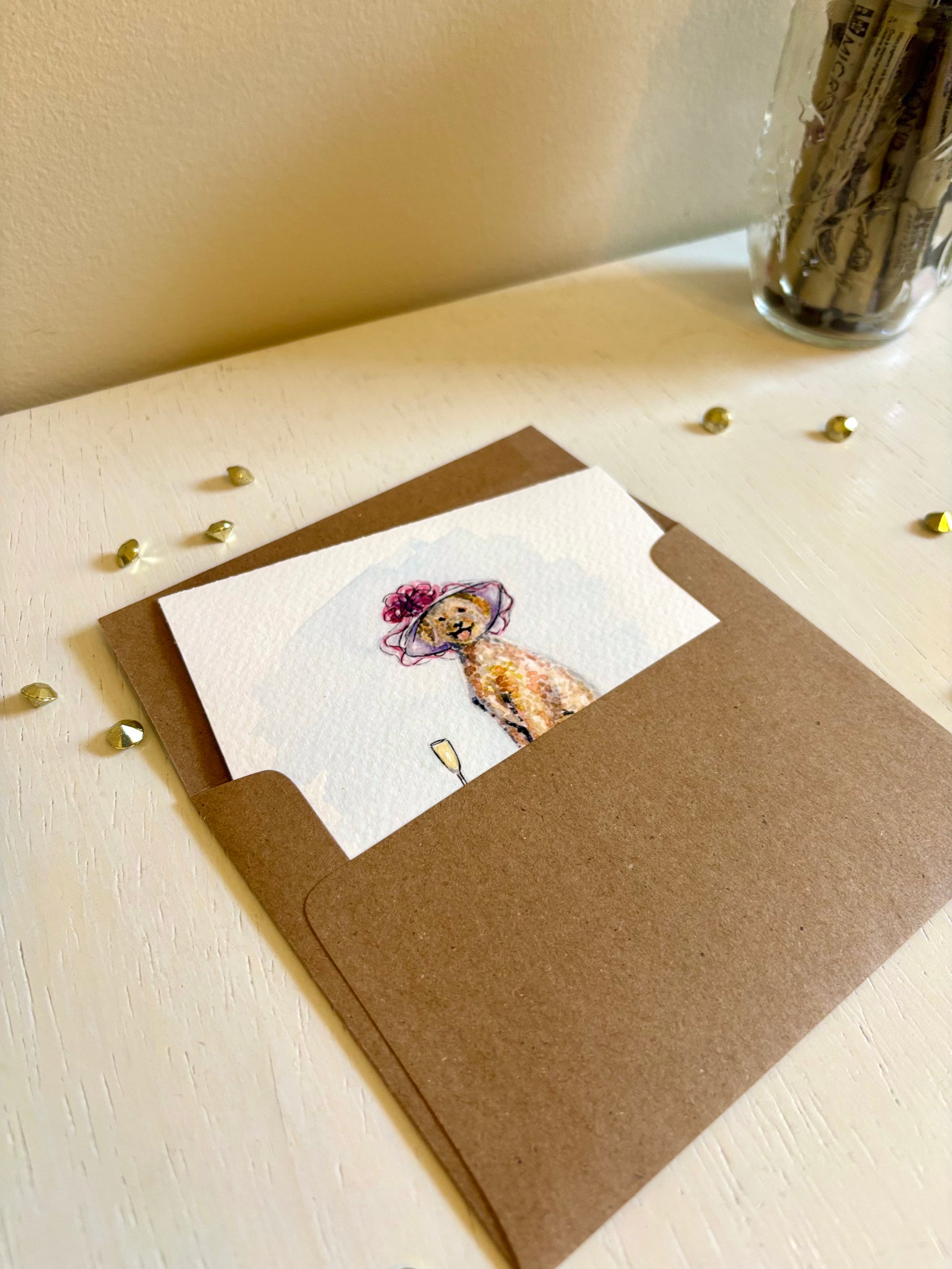 Greeting card fine art print with a watercolor illustration of a Golden Doodle dog wearing a derby hat on a brown envelope.