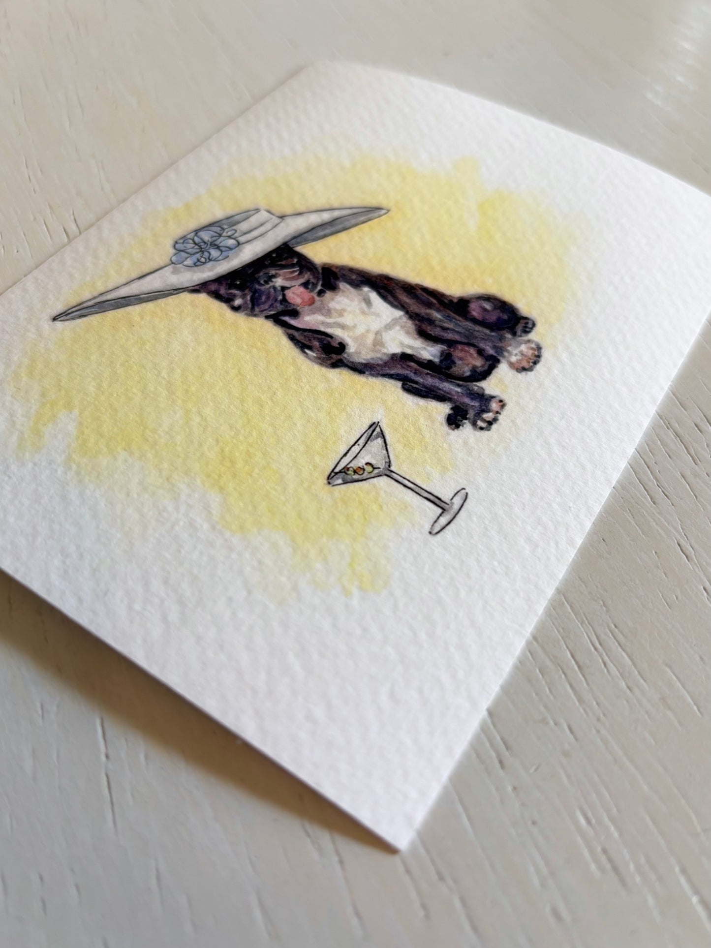 Art print close-up with a dog wearing a hat and holding a martini glass on a yellow background
